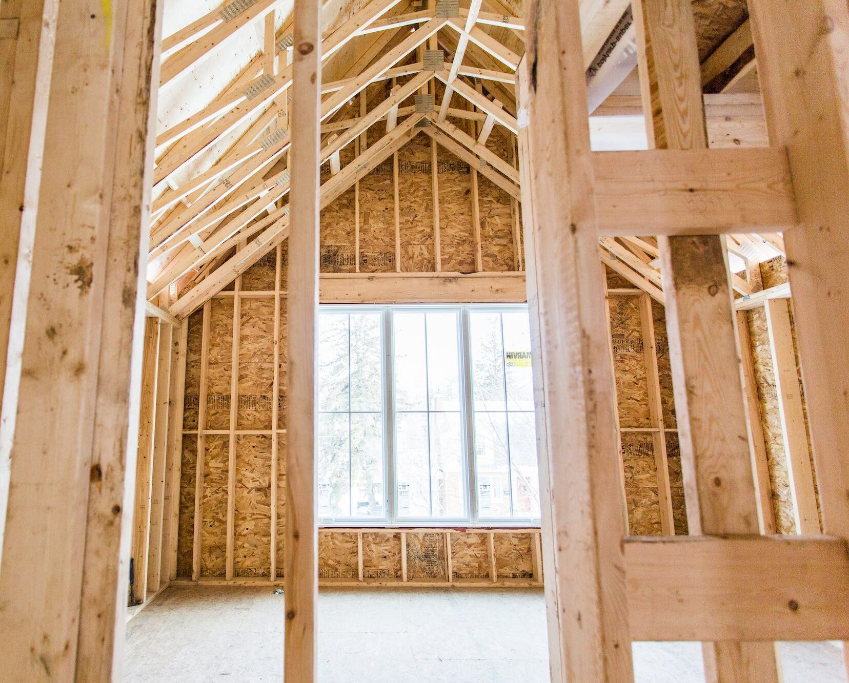 Interior view of a framed room under renovation, showcasing wooden beams and walls, emphasizing the construction process for home renovations in Stoney Creek.